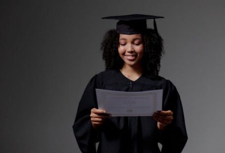 Certifications - Curly-haired graduate student holding certificate