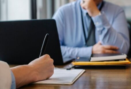 Accreditation Review - Crop anonymous female filling questionnaire when applying for job sitting in employer office