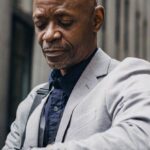 Time Management Tools - Busy black executive checking time on wristwatch on street