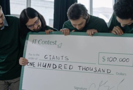 Grants - Team Holding a Big Check Happy About Winning Additional Funding