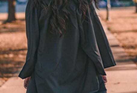 Degrees - Woman in Black Long Sleeve Dress Standing on Brown Concrete Pathway