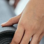 Readiness - Crop female holding rolled mat on floor
