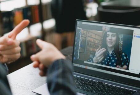 Language Requirements - Young lady learning sign language during online lesson with female tutor