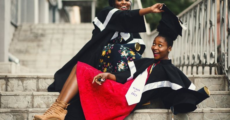 Degrees - Shallow Focus Photography of Two Women in Academic Dress on Flight of Stairs