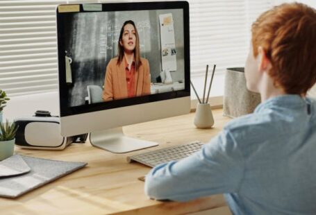 Online Education - Photo of Child Sitting by the Table While Looking at the Imac