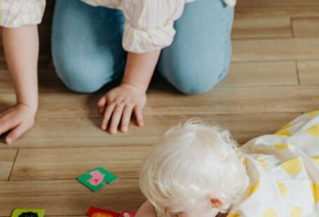 Flashcards - A Woman Kneeling on Floor Watching a Baby Playing with Flashcards