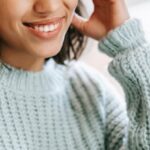 Online Exams - Hispanic woman working remotely on laptop near notepad in apartment